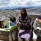 María Iza cuida de sus nietos mientras su hija trabaja. Ella pide el internet a una vecina para que accedan a sus clases.