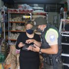 La afectada y un policía revisan las grabaciones de las cámaras de seguridad.