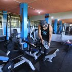 Luis Higuera alista las máquinas para la reapertura de su gimnasio en Amaguaña.