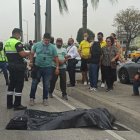 El cadáver fue cubierto con un plástico negro. Un familiar llegó para identificarlo.