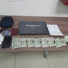 El talonario de citaciones, dinero, una laptop y otros objetos encontrados al detenido.