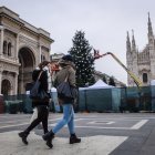 Italianos transitan cerca de un árbol de Navidad en Milán.