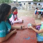 Con la ayuda de cartones numerados, Denisse Toala enseña la materia de matemáticas a tres pequeñas.