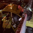 Los policías revisan el interior del taxi donde quedó el cadáver.