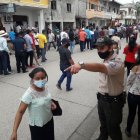 Un policía trata de poner orden en la calle llena de votantes.