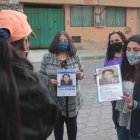 Carol Manzano entrega afiche de su madre desaparecida a los recicladores de basura para que la ayuden a encontrarla.