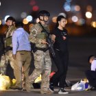 Un policía escolta a una mujer mientras un grupo de venezolanos es deportado en el Aeropuerto Internacional de Lima, el 27 de enero de 2020.