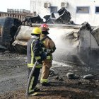 Bomberos tratan de apagar el fuego en lo que quedó del tanquero incendiado.