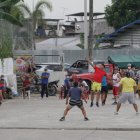 En la ciudadela Martha de Roldós, atrás de donde se construye un nuevo mercado, los residentes juegan ecuavóley. Otros lugareños los ven, pero no todos se cuidan del coronavirus.