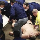 El luchador yace en el piso tras el mortal golpe, mientras tratan de auxiliarlo.
