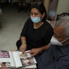 Los padres de Lisbeth, Katty Muñoz y Mario Baquerizo revisan el álbum donde guardan las fotos de su amada hijaECUADOR