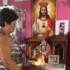 Nube Dolores mantiene todo el día una vela encendida por su hija Johanna Tapia. Su foto está en medio de varias imágenes de santos.