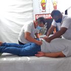 Yulica, Hernando Niño y Édison Hurtado con un paciente en su carpa. El en el fondo se observa parte de la noria del Malecón del Río.