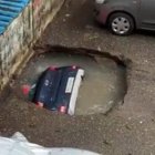 El carro cuando se hundía en el hoyo lleno de agua.