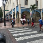 Con el semáforo peatonal en rojo, igual varios peatones se lanzan a cruzar la calle, incluso fuera de la zona de seguridad.