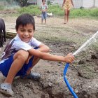 Un 'pelado' con rostro feliz riega la calle con una manguera, algo que no se veía por La Chontilla hace mucho tiempo.