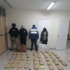 Los dos detenidos junto a los policías y la droga incautada en una casa de Tulcán.