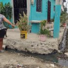 Una moradora muestra la presencia de las aguas residuales en las calles.