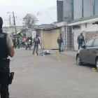 Un policía observa la escena del crimen, donde yace la víctima baleada.