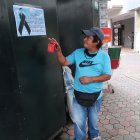. Desconsolado, Segundo observa el afiche que amigos de la fallecida, Esmeralda Aguilar Bolaños (círculo), colocaron en la puerta de su negocio.