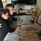 La madre y el abuelo del joven en el dormitorio donde él dormía. Muestran sus medallas.