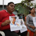 Olimpia Cruz y Mireya Pincay  muestran las hojas impresas con los rostros de sus seres queridos. Piden ayuda a la Policía y a la ciudadanía.