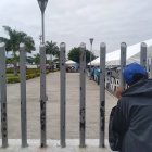 Entre los barrotes de la morgue policial, Juan asoma su cabeza esperando tener noticias de su familiar.