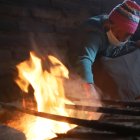 María Juiñia muestra cómo  se cocina con leña; ella se resiste a dejar esa tradición.