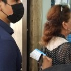 Con su carnet de vacunación a la mano, un ciudadano espera su turno para ingresar a una entidad pública para realizar un trámite.