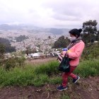 María Sangucho camina por una trocha desde donde se mira la mancha urbana del norte de Quito.