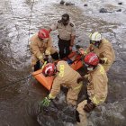 Rescatistas y la Policía sacan el cuerpo del río.
