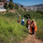 Hombres vestidos de Reyes Magos caminan en un caserío dentro del Cementerio General del Sur, hoy, en Caracas (Venezuela). En Venezuela, los Reyes Magos atravesaron este miércoles, 6 de diciembre, el principal cementerio público del país para llevar la alegría de sus colores y regalos a más de 80 niños de una comunidad olvidada en la que los recibieron con los pies descalzos y sonrisas eufóricas. Ni siquiera las cruces, lápidas, coronas de flores y todo el mármol gris del Cementerio General del Sur apagaban los colores de las capas de los tres Reyes Magos que caminaron, junto a un grupo de voluntarios, parte de las 240 hectáreas del lugar para llegar a Barrio Nuevo, una comunidad del oeste de Caracas que se estableció dentro de los linderos de este camposanto. EFE/ Rayner Peña R.