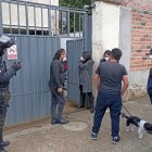 Afectada junto a familiares y curiosos en la puerta de la vivienda donde se robaron el dinero de la caja fuerte.