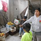 Leticia muestra las frutas que se echaron a perder en el negocio de su hermano.