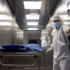 Personal de salud traslada a un paciente fallecido por la covid-19