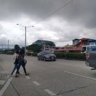 Con cuidado los peatones cruzan la vía en la cual circulan buses, camiones, etcétera.