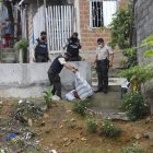El cadáver fue encontrado en un barranco y con señales de haber sido atacado con un cuchillo. Policías cubrieron el cuerpo con una sábana.