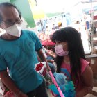 Ana Dávila junto a su padre comprando un detalle para la madre de la niña.