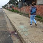 <unsa joven camina junto al sitio donde el último domingo fue asesinado un hombre.