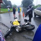 La moto y su conductor yacen en la calzada luego del percance mortal.