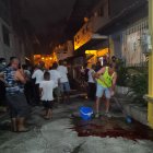 Un vecino del callejón Santa Ana, en Manta, trata de limpiar con agua y detergente el charco de sangre que quedó de la víctima.