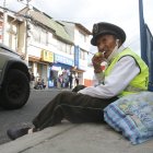 Por su edad, este hombre se sienta en la vereda y desde ahí intenta dirigir a los choferes.