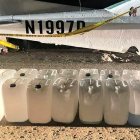 Las canecas con gasolina junto a la avioneta.