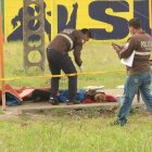 La víctima yace en el piso, mientras agentes de la Policía realizan los trámites de ley.