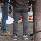 Agentes de Criminalística rodean el cuerpo del hombre asesinado junto a su negocio.