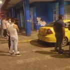 Policías junto al taxi que fue víctima de un ataque de hampones y donde la pasajera resultó muerta.