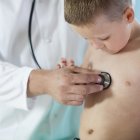 Doctor makes chest auscultation to little patient