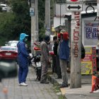 Los enganchadores de las mecánicas aguardan por los usuarios cerca del puesto de revisión vehicular.
