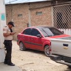 El agente estaba en el interior de un vehículo rojo.