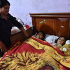 María Chiluisa recuesta a las dos niñas que están bajo su cuidado.